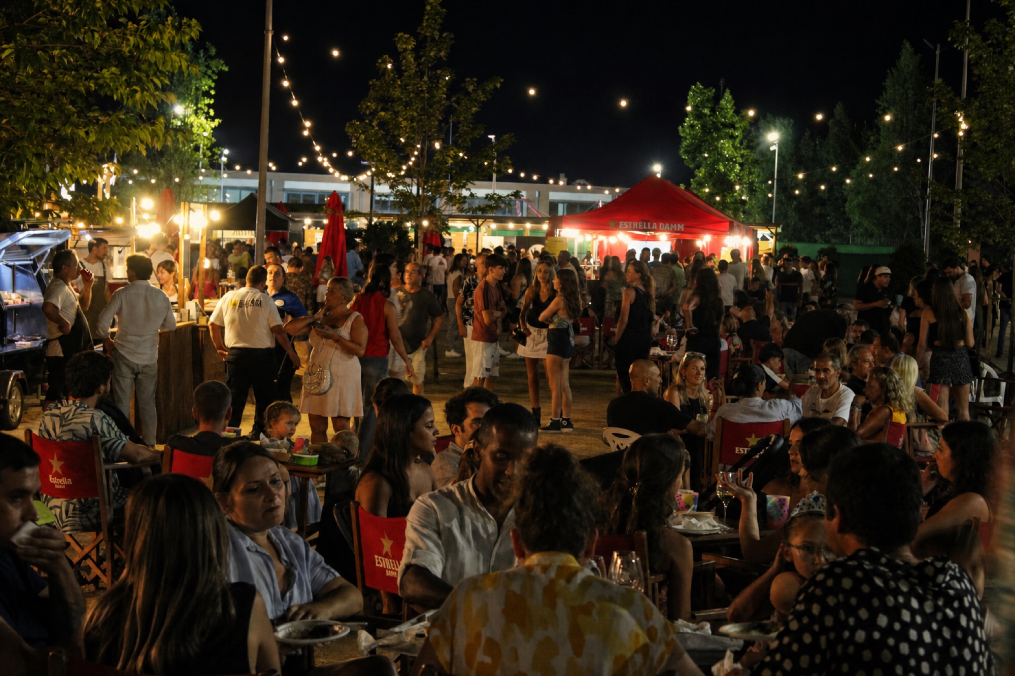 Gran terrassa gastronòmica nocturna amb food trucks i públic